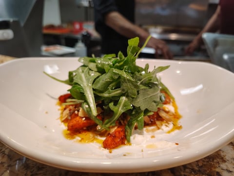 Roasted harissa carrots with labneh, toasted almonds and a pile of dressed arugula